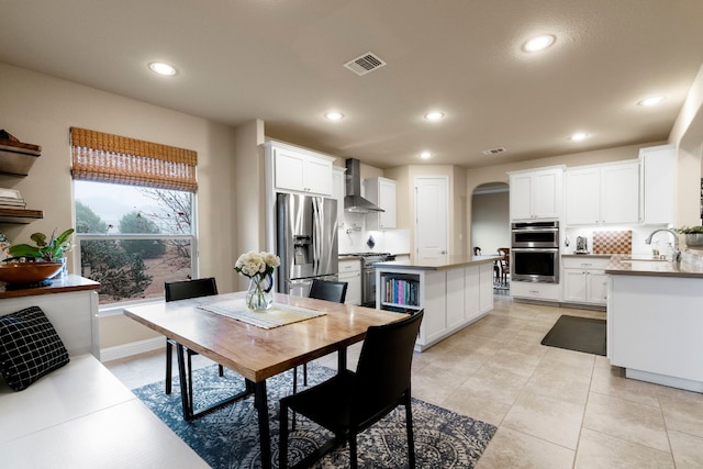 dining space with recessed lighting, visible vents, arched walkways, and baseboards