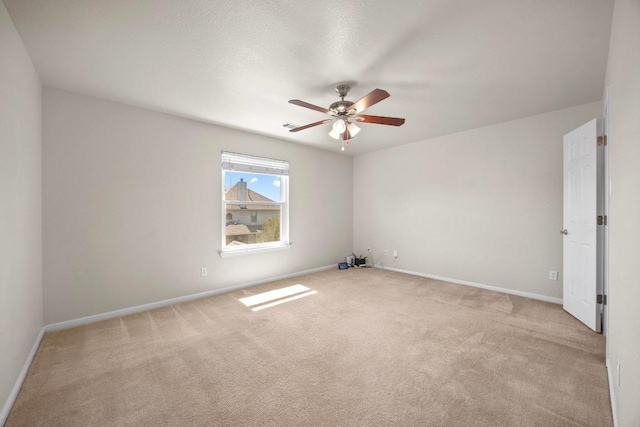 empty room featuring carpet flooring, a ceiling fan, and baseboards