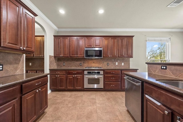 kitchen featuring dark countertops, visible vents, appliances with stainless steel finishes, and crown molding