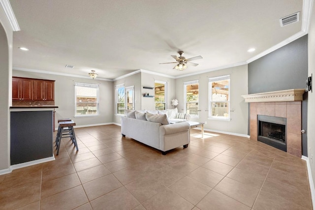 living room with visible vents, baseboards, a tile fireplace, and tile patterned flooring