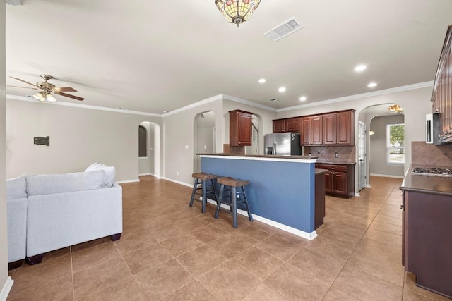 kitchen with open floor plan, visible vents, arched walkways, and appliances with stainless steel finishes