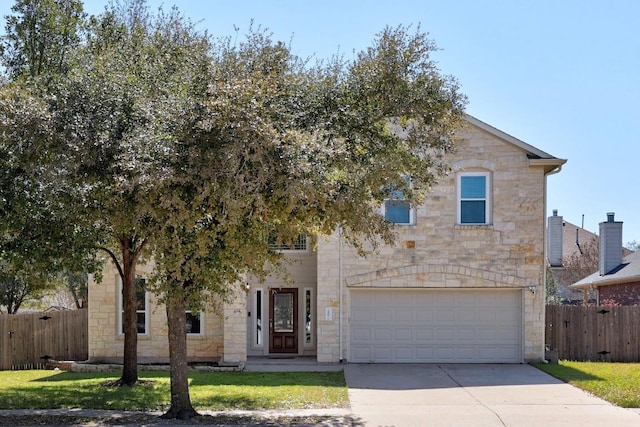 view of front facade with fence, concrete driveway, a front yard, a garage, and stone siding