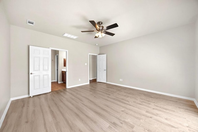 unfurnished bedroom featuring visible vents, ceiling fan, baseboards, ensuite bathroom, and light wood-style floors