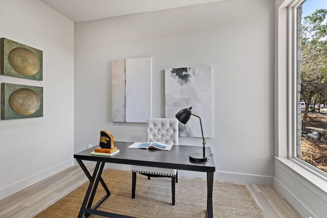 office area with baseboards and light wood finished floors