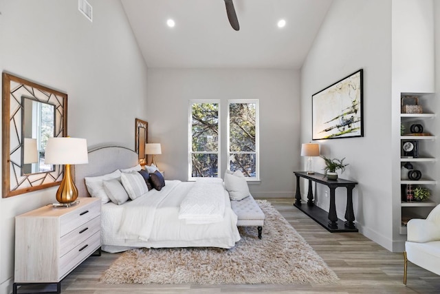 bedroom with visible vents, recessed lighting, high vaulted ceiling, and wood finished floors