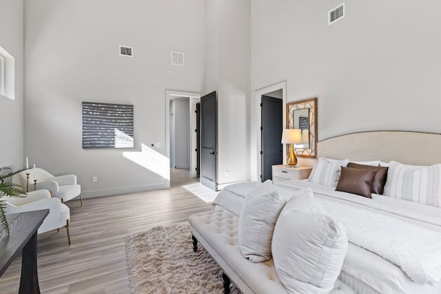 bedroom featuring visible vents, light wood-style flooring, and baseboards