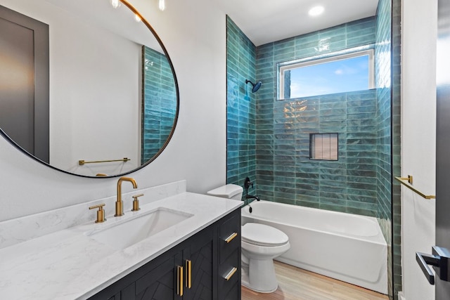 bathroom featuring vanity, toilet, wood finished floors, and  shower combination