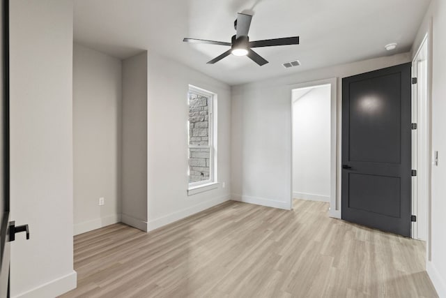 unfurnished bedroom with a ceiling fan, baseboards, visible vents, and light wood-type flooring