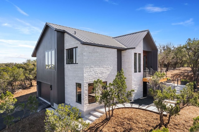 view of home's exterior featuring brick siding, metal roof, and a standing seam roof