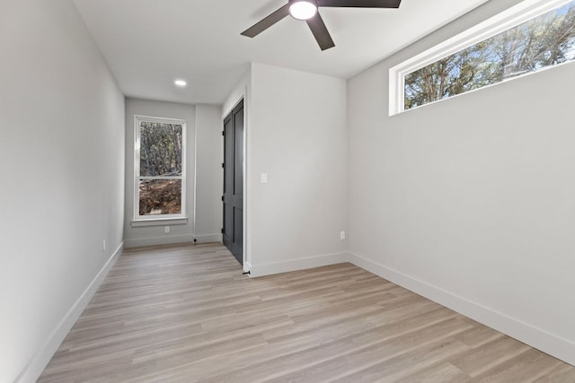 empty room with light wood finished floors, ceiling fan, and baseboards