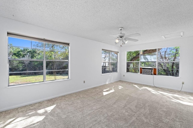 carpeted empty room with a ceiling fan, baseboards, and a textured ceiling