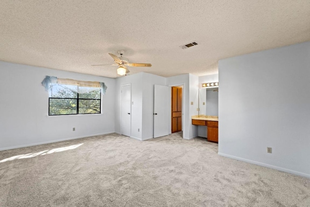 unfurnished bedroom with visible vents, light colored carpet, built in study area, and baseboards