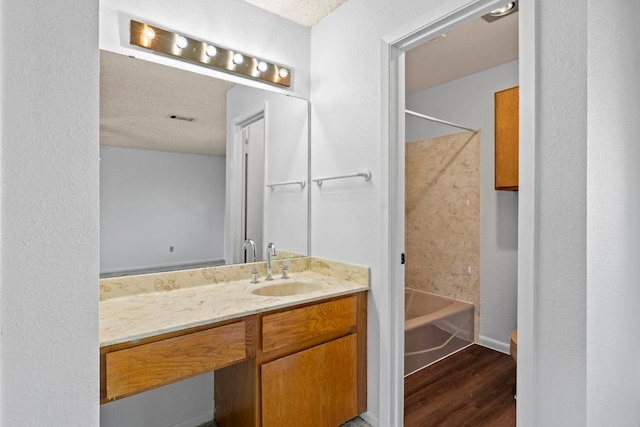 bathroom featuring visible vents, shower / washtub combination, vanity, and wood finished floors