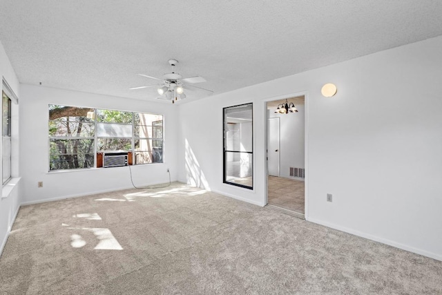 carpeted empty room with baseboards, visible vents, a textured ceiling, and a ceiling fan