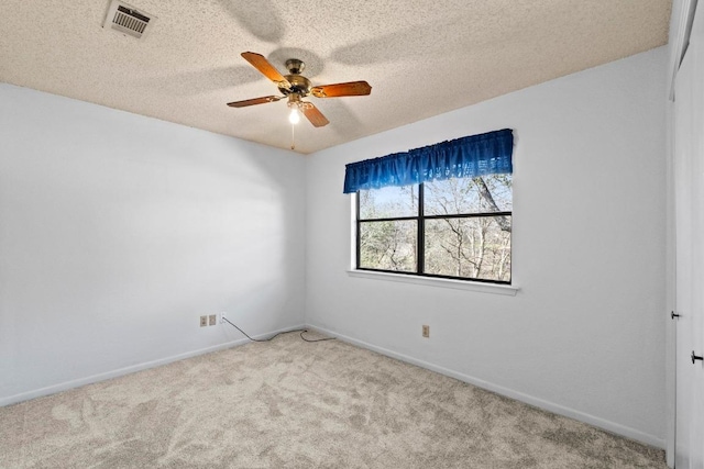 carpeted empty room with baseboards, a textured ceiling, and ceiling fan