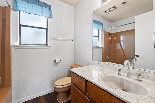 bathroom with baseboards, toilet, wood finished floors, vanity, and a shower