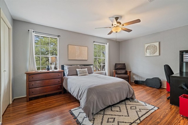 bedroom with multiple windows, wood finished floors, and a ceiling fan