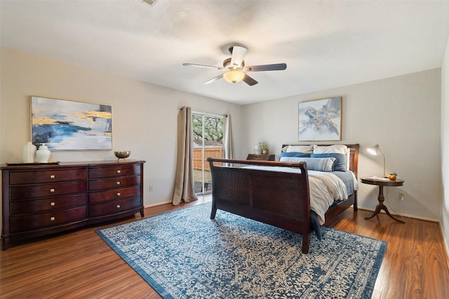 bedroom featuring baseboards, wood finished floors, a ceiling fan, and access to exterior