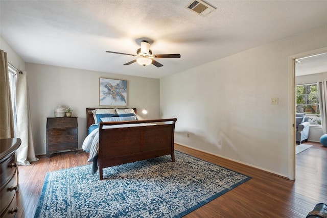 bedroom featuring visible vents, baseboards, wood finished floors, and a ceiling fan