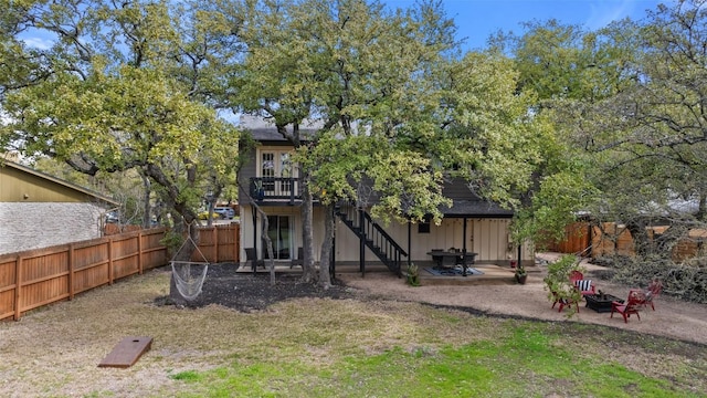 rear view of house with stairway, a patio, fence private yard, and an outdoor fire pit