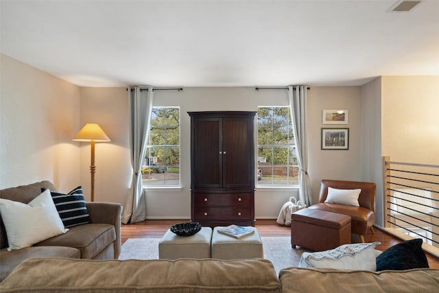 living area with visible vents, baseboards, and light wood finished floors