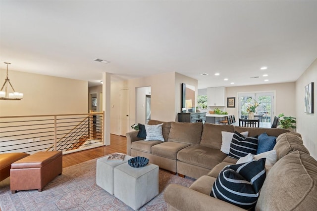 living room featuring recessed lighting, a chandelier, visible vents, and wood finished floors