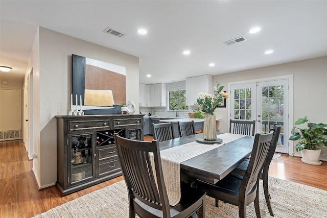 dining area featuring visible vents, a healthy amount of sunlight, and light wood-type flooring