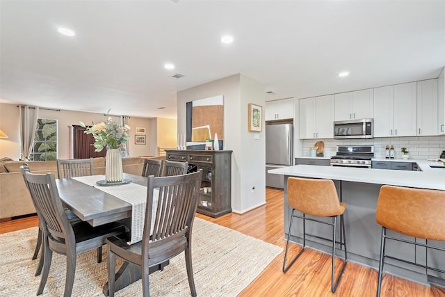 dining space with recessed lighting, visible vents, and light wood-style flooring