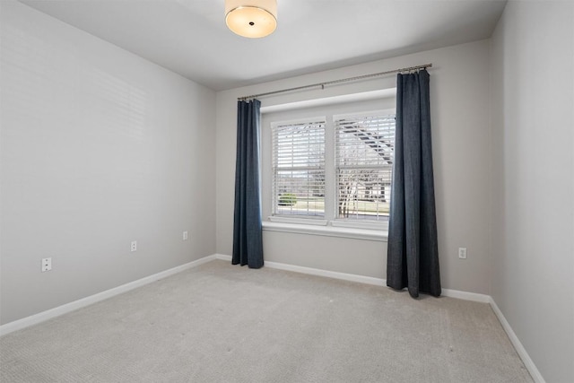 unfurnished room with light colored carpet and baseboards