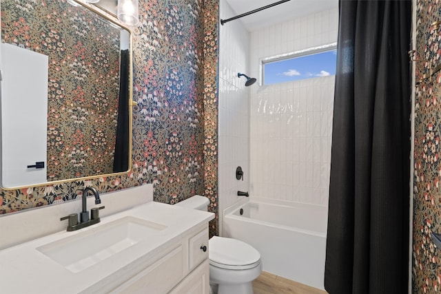 bathroom featuring vanity, wood finished floors, shower / bathtub combination with curtain, wallpapered walls, and toilet