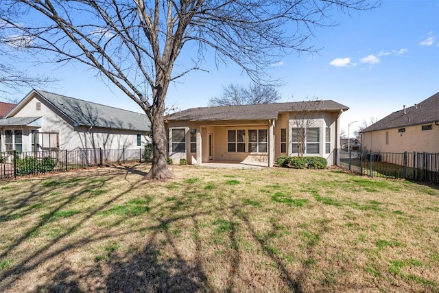 rear view of property with a lawn, fence, and stucco siding