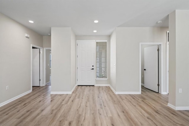 spare room featuring light wood finished floors, recessed lighting, and baseboards