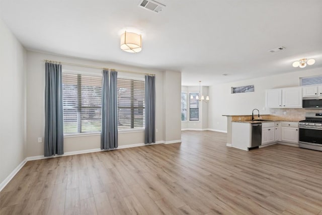 kitchen featuring visible vents, white cabinets, stainless steel appliances, and a sink