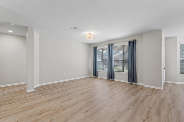 unfurnished room featuring baseboards, visible vents, and light wood finished floors