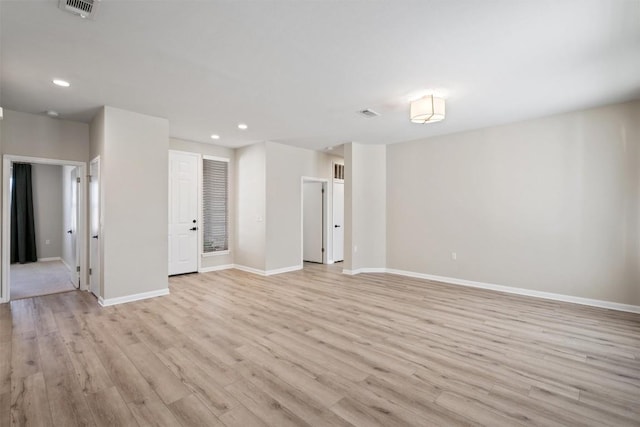 empty room with light wood finished floors, visible vents, recessed lighting, and baseboards