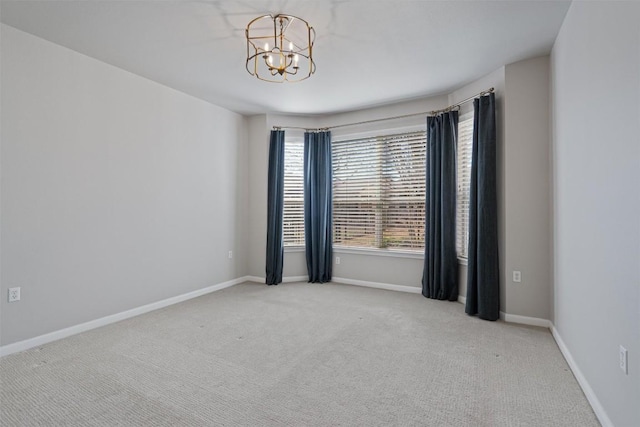 empty room with baseboards, carpet, and a chandelier