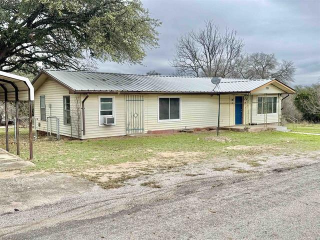 ranch-style house featuring a detached carport, cooling unit, driveway, and metal roof