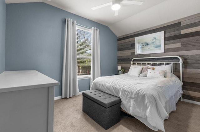 bedroom featuring wooden walls, light colored carpet, lofted ceiling, and ceiling fan