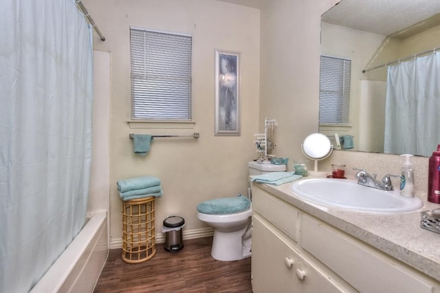 full bathroom with toilet, shower / tub combo with curtain, wood finished floors, baseboards, and vanity