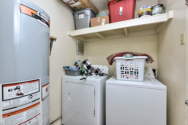 washroom with laundry area, washing machine and dryer, and water heater