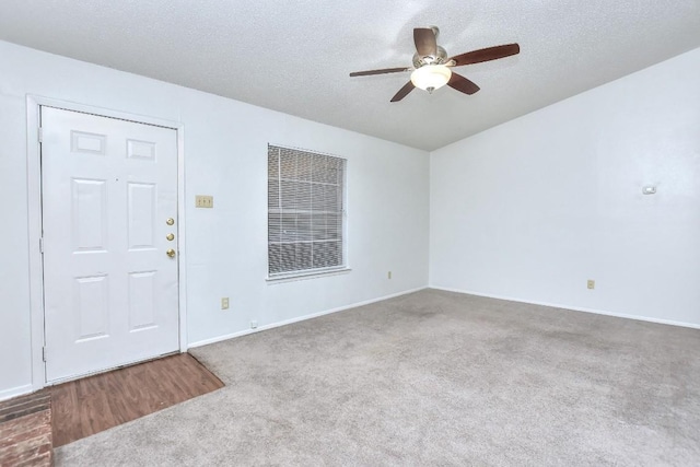 interior space with ceiling fan, carpet flooring, baseboards, and a textured ceiling