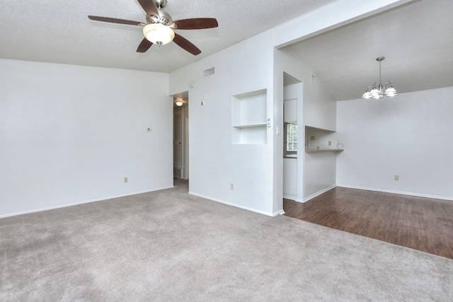 unfurnished living room featuring baseboards, carpet flooring, a textured ceiling, and visible vents