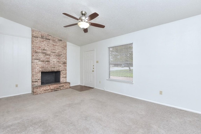 unfurnished living room featuring carpet, lofted ceiling, a fireplace, ceiling fan, and a textured ceiling