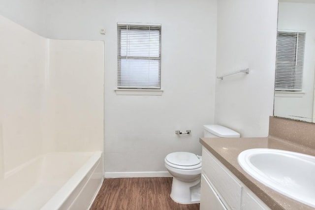 full bath with toilet, vanity, baseboards, and wood finished floors