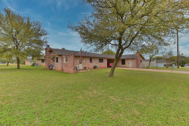 single story home featuring brick siding, driveway, a chimney, and a front yard