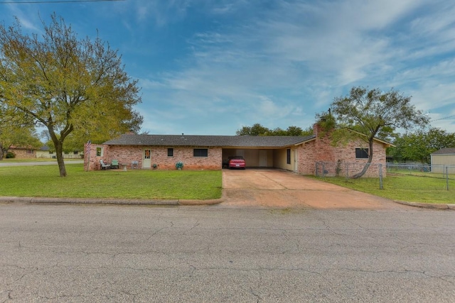 ranch-style home featuring fence, driveway, a chimney, a front lawn, and a carport