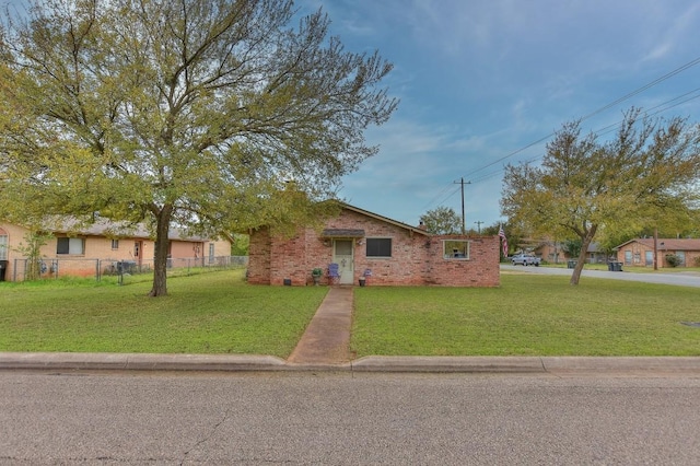 ranch-style home featuring brick siding, a front lawn, and fence