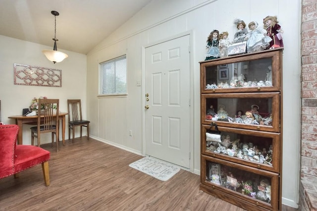 entrance foyer featuring baseboards, lofted ceiling, and wood finished floors