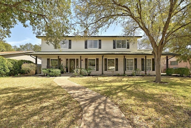 view of front of property with a front lawn, covered porch, and brick siding