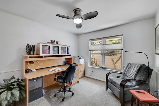 office space with ceiling fan, baseboards, and light carpet